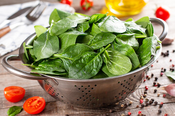 Natural organic fresh spinach in a metal sieve on a table