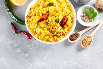 A balti dish with lemon rice, rice flavoured with mustard seeds, curry leaves and green chili in a bowl. Top view with copy space.