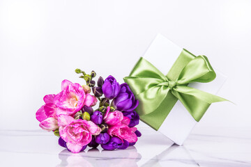 White gift box and flowers. Box with a bow. Gift for a woman