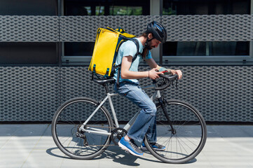 Young bearded courier delivering food on a bicycle, checking order with a smart phone .Delivery service concept