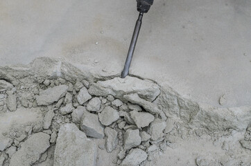 A builder dismantles a perforator drill breaks the concrete floor at a construction site	
