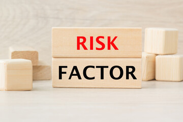 the words RISK FACTOR are written on a wooden cubes structure. Cube on a bright background. Can be used for business, financial, MEDICAL concept. Selective focus.