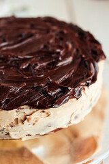 Delicious round cake with white buttercream topped with chocolate frosting, coating