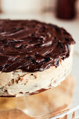 Delicious round cake with white buttercream topped with chocolate frosting, coating