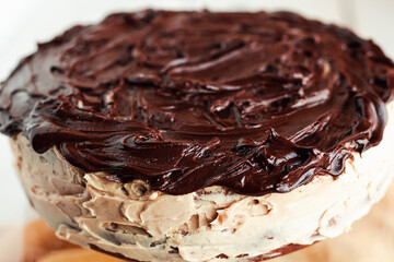 Delicious round cake with white buttercream topped with chocolate frosting, coating. Holiday and festive food concept