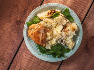 Healthy breakfast with cauliflower, eggs and baked chicken breast on a salad plate