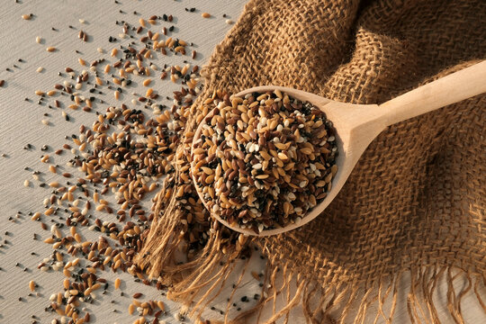 Seeds, flax, sesame, cumin in a wooden light spoon on the table, scattered nearby. The concept of proper nutrition, diet food, weight loss
