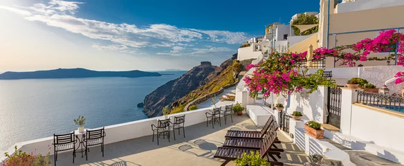 Poster Summer vacation panorama, luxury famous Europe destination. White architecture in Santorini island, Greece. Travel landscape cityscape with pink flowers, stairs, caldera view in sunlight and blue sky © icemanphotos