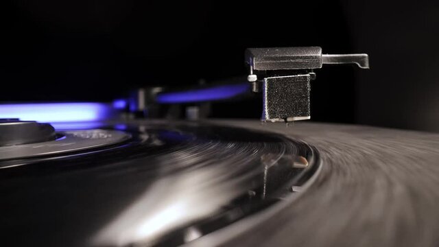 Needle touches down in a vinyl record - close-up view