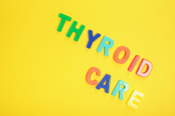 inscription thyroid care on yellow background, diagnosis and treatment of thyroid disease concept