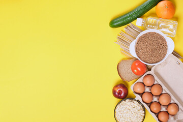 fruits, vegetables, cereals, bread, noodles and a bottle of water on a yellow background copy space