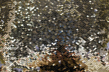 Black and gold sequins close-up texture. Shiny fabric background. black sequins. Gold glittering double-sided material, glittering background. Fashionable fabric for decor