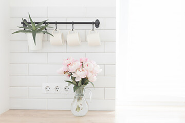 Bouquet of pink peonies. Modern interior in the kitchen. Wedding and festive style.