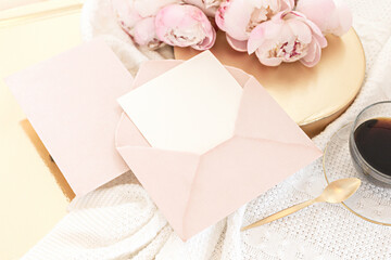 Wedding greeting card concept. Top view mockup on wooden background with peonies flowers. Flat lay style in light colors.