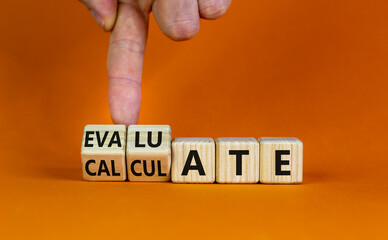Calculate or evaluate symbol. Businessman turns wooden cubes and changes the word 'evaluate' to 'calculate'. Beautiful orange background, copy space. Business, calculate or evaluate concept.