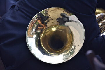 A French horn in the hands of a musician, during a classical music concert