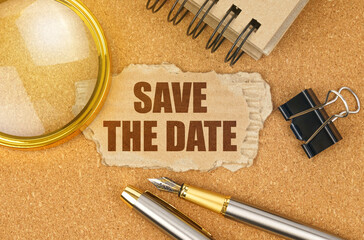 On the table are office items and a cardboard with the inscription - SAVE THE DATE