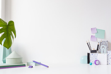 Creative desk with empty space for product montage, desk objects, office supplies, books, and plant...