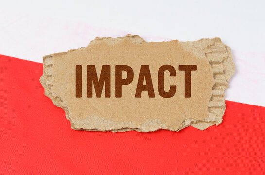 Against the background of the Polish flag lies cardboard with the inscription - impact - Powered by Adobe