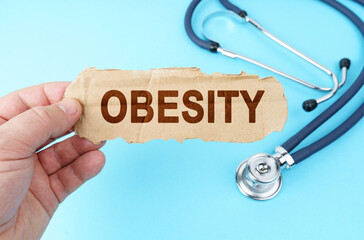 On a blue background, a man holds a cardboard box with the inscription - OBESITY
