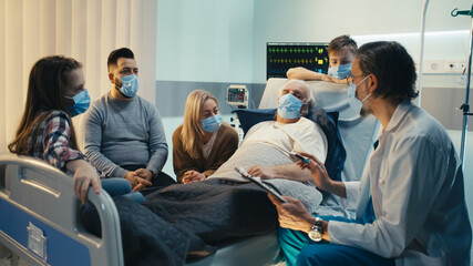 Mature doctor speaking with senior patient and family