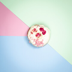 Fototapeta na wymiar Doughnut with with chocolate and raspberry and pink chocolate on blue, pink and green background. Top view.