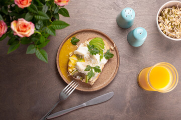 Light summer breakfast - sandwich with avocado, cottage cheese, sprouted beans and poached egg with orange juice on the table top view