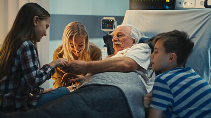 Senior patient speaking with daughter and grandchildren in hospital