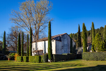 Small village house surrounded by cypress trees - typical rural landscape in Provence on a sunny...