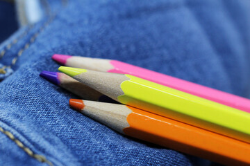 Bright colored pencils on jeans