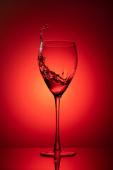 Still-life with the wine glass. Glass on a red background