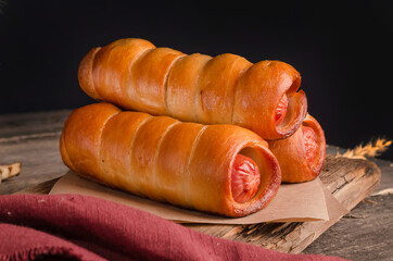 Appetizing fresh culinary pastry - sausages in pastry on wooden