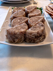Poultry jelly cut into crescents on a white dish on the table. Good for party food.