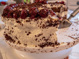 Black Forrest cake with cherries on a plate on a tablecloth covered table. Good for party food.
