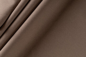 Fototapeta premium thick curtain cotton fabric of coffee color, folded in folds, background
