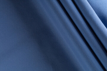 thick curtain cotton fabric of azure color, folded in folds, background