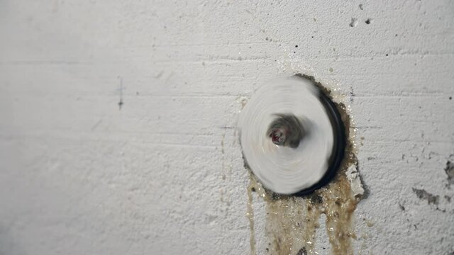 Breakthrough of a Core driller through a concrete wall with cooling water