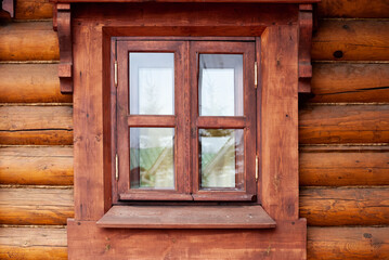 Naklejka na ściany i meble A window with a wooden profile in a house made of beams.