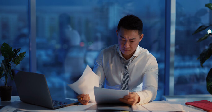 Asian Angry Businessman Having Problems At Work Hitting The Table Getting Frustrated Working Long Hours Finishing Project Missing Deadline. Emotions.