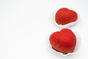 A bright red heart-shaped cakes on a white background. Copy space