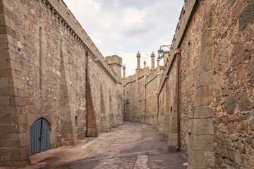 The walls and towers of the old palace on the background of a cloudy sky