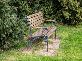View of a wooden bench with metal legs in the garden.