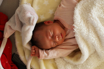 Un bébé dort dans son pyjama rose