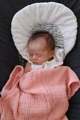 Bébé dormant avec une couverture rose en photo verticale