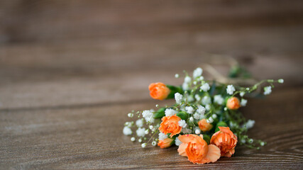 Delicate bouquet of carnations and gypsophila on wooden background. Image with selective focus