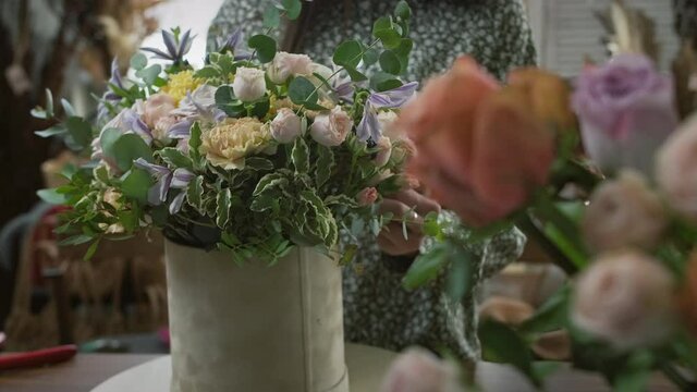 Process of creating beautiful composition of fresh flowers in floral vintage workshop or store. Small business engaged in delivery and sale of bouquets