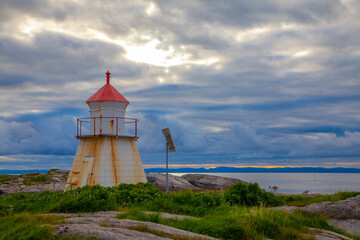 Fototapeta na wymiar Little unmanned lighthouse in weather-hardened fishing village on the coast of Norway