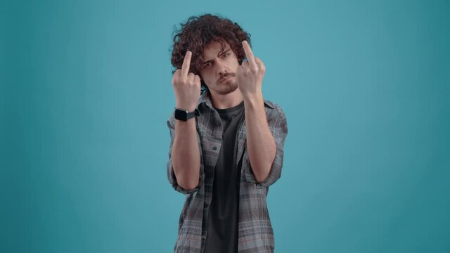 The serious, angry young man shows with both hands fuck you. Isolated on black background, Concept of life. People's emotions. 4k portrait