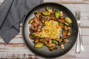 Plate of Brussels sprouts with portobellos and mushrooms with bacon and scrambled eggs. Aerial view.