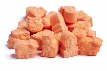 Orange animal shape vitamins for kids isolated on a white background. Assorted animal shaped multivitamins for kids. Chewable pills
